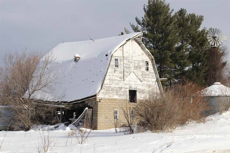 Snow covered barn with collapsing roof